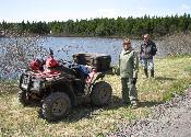 Friends taking a brief rest next to scenic pond